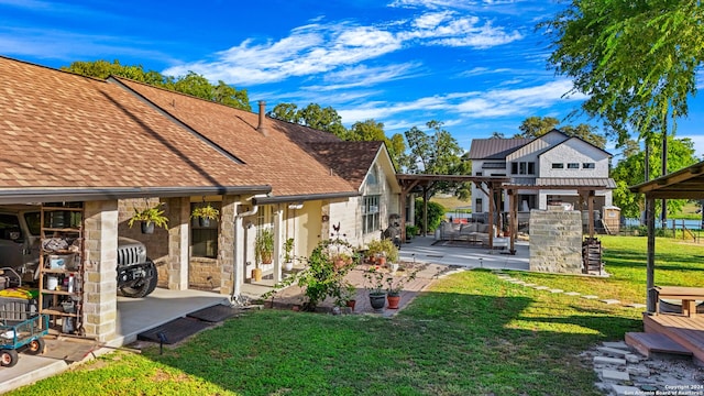735 Hot Shot Ln, Mcqueeney, TX 78123 - back of house featuring a lawn, a patio area, a shingled roof, and stone siding