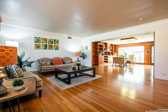 living room featuring crown molding, wood finished floors, and visible vents