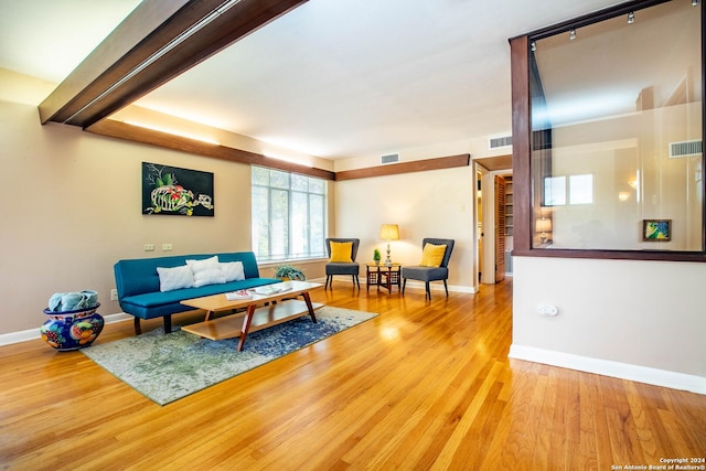 living room featuring visible vents, baseboards, and wood finished floors