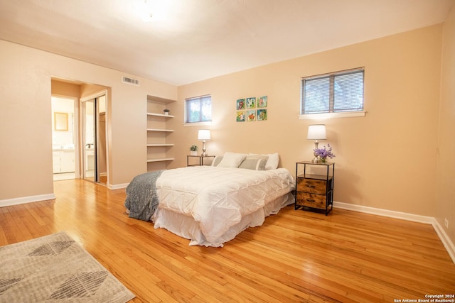 bedroom featuring visible vents, baseboards, and light wood-style floors