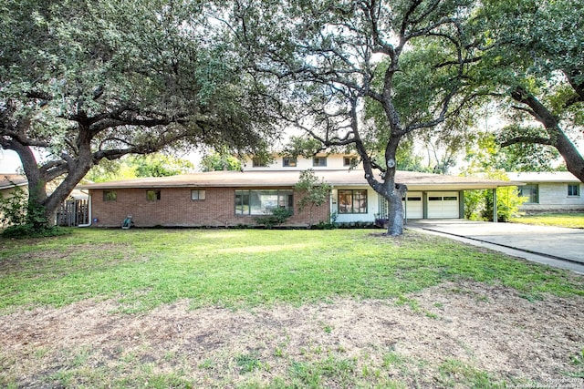 ranch-style home with concrete driveway, an attached garage, brick siding, and a front yard