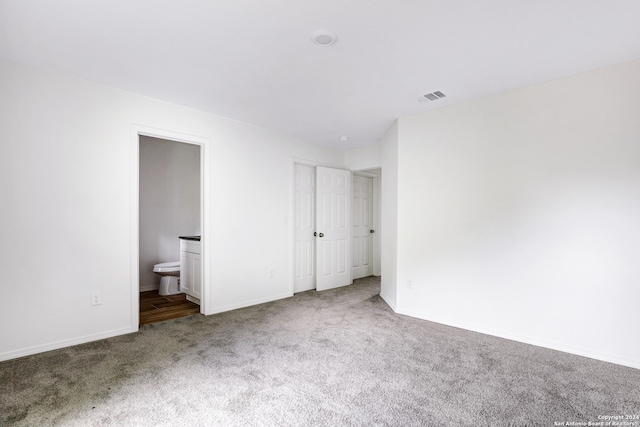 unfurnished bedroom with ensuite bath and light carpet