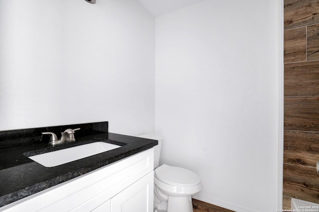 bathroom with hardwood / wood-style floors, toilet, and vanity