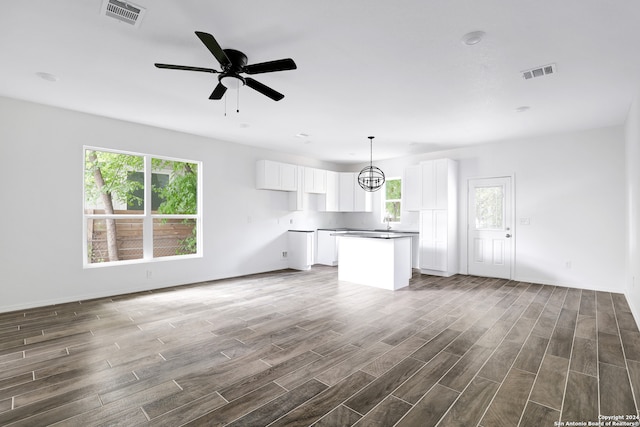 unfurnished living room with ceiling fan and wood-type flooring