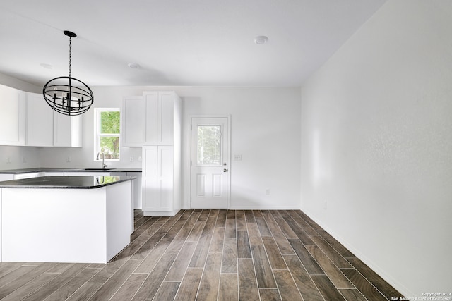 kitchen featuring a chandelier, dark hardwood / wood-style floors, sink, pendant lighting, and white cabinets