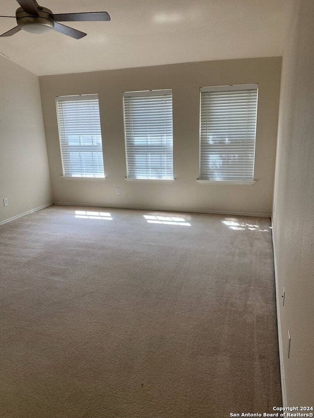 empty room with ceiling fan and carpet floors