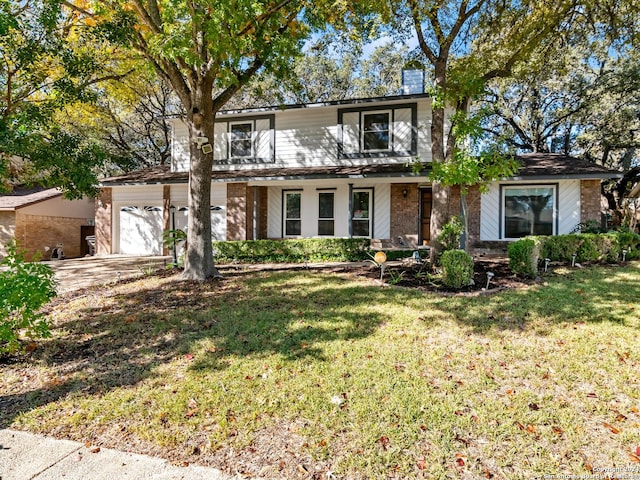 view of property featuring covered porch, a front yard, and a garage