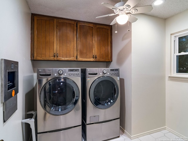 clothes washing area featuring washing machine and clothes dryer, ceiling fan, cabinets, and a textured ceiling