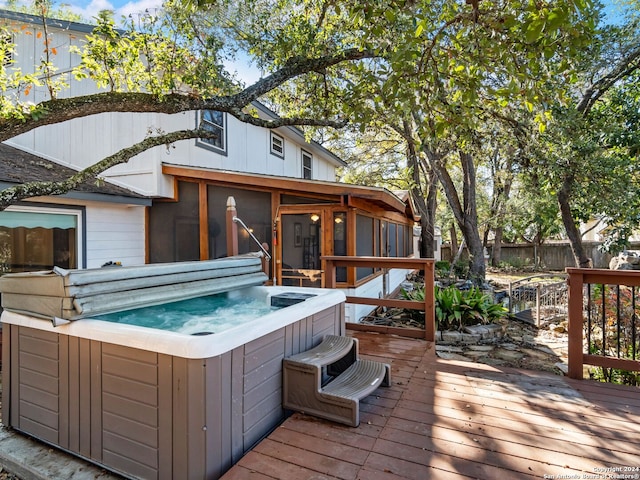 wooden deck featuring a sunroom and a hot tub