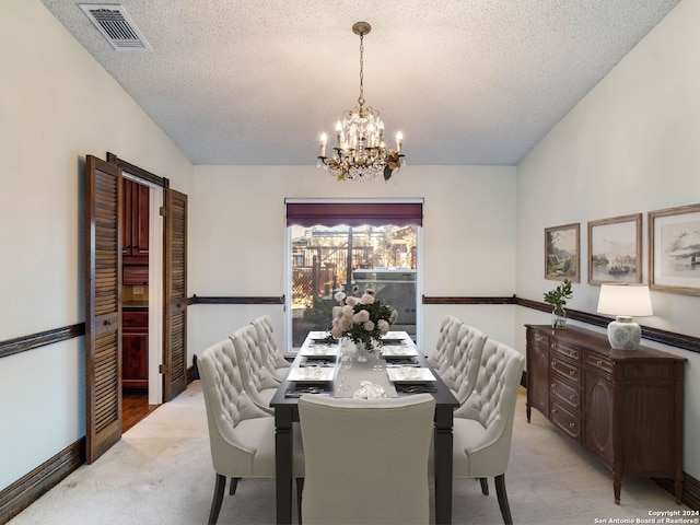 carpeted dining room featuring lofted ceiling, a chandelier, and a textured ceiling