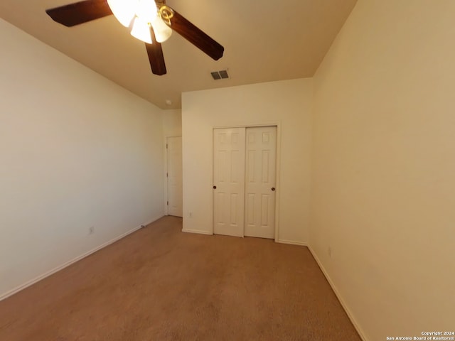 unfurnished bedroom featuring carpet flooring, ceiling fan, and a closet