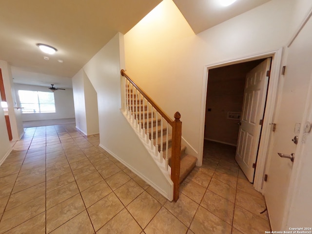 stairs featuring ceiling fan and tile patterned flooring