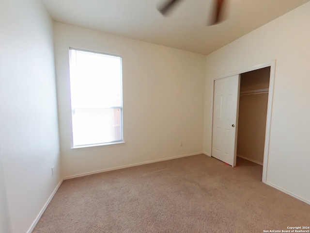 unfurnished bedroom with a closet, ceiling fan, and light colored carpet