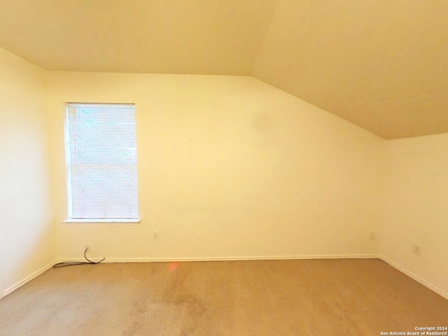 additional living space featuring carpet and lofted ceiling