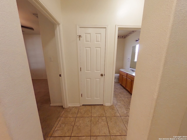 hall with light tile patterned flooring and sink