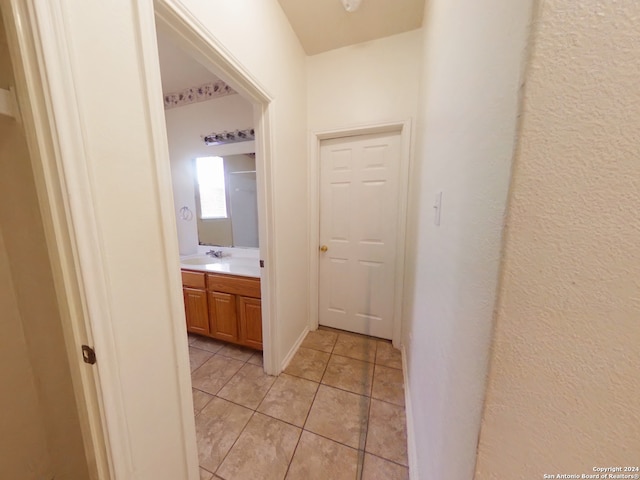 hall with sink and light tile patterned flooring