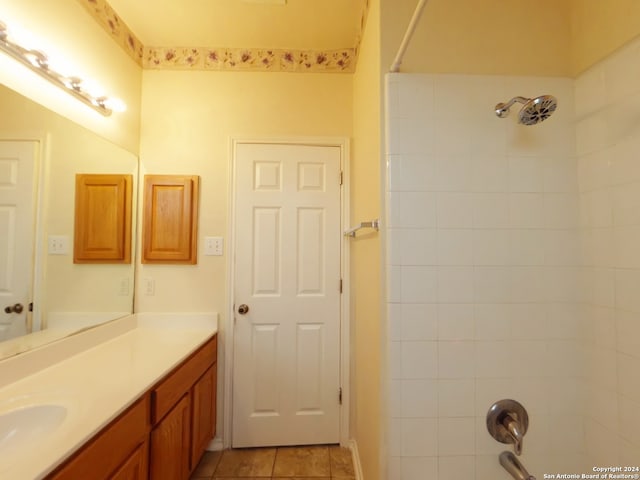 bathroom featuring a tile shower, vanity, and tile patterned floors