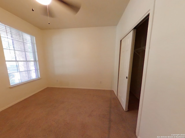 interior space featuring carpet flooring, ceiling fan, and a closet