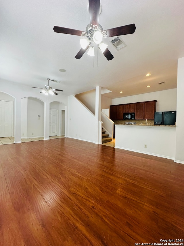 unfurnished living room with ceiling fan and light hardwood / wood-style floors