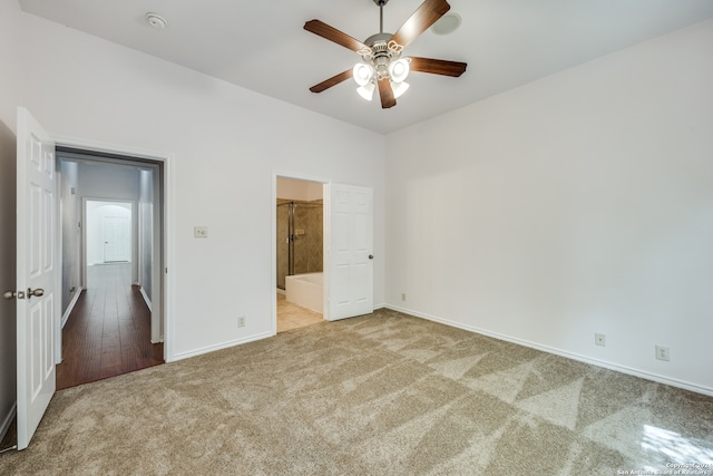 unfurnished bedroom with ceiling fan, ensuite bathroom, and light carpet