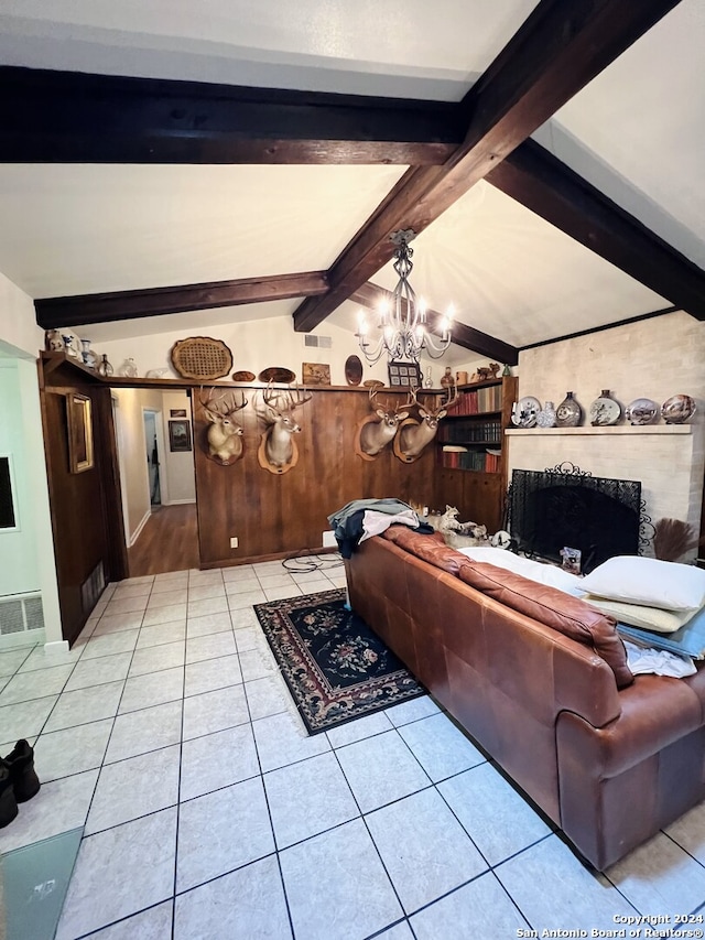 living room featuring a notable chandelier, lofted ceiling with beams, light wood-type flooring, and a premium fireplace