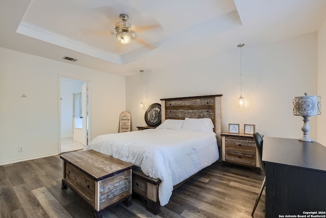 bedroom featuring dark hardwood / wood-style flooring, a raised ceiling, ensuite bathroom, and ceiling fan