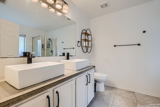 bathroom with tile patterned floors, toilet, vanity, and a shower with shower door