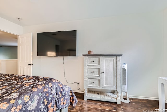 bedroom with dark hardwood / wood-style floors