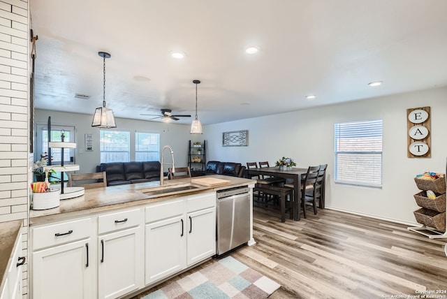 kitchen featuring ceiling fan, stainless steel dishwasher, white cabinets, light hardwood / wood-style floors, and sink