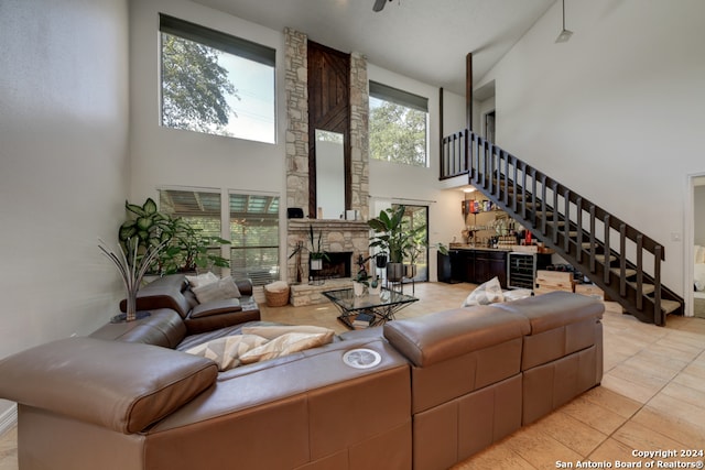 tiled living room featuring a high ceiling and a fireplace