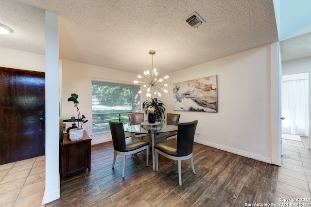 dining space with a notable chandelier, a textured ceiling, and wood-type flooring