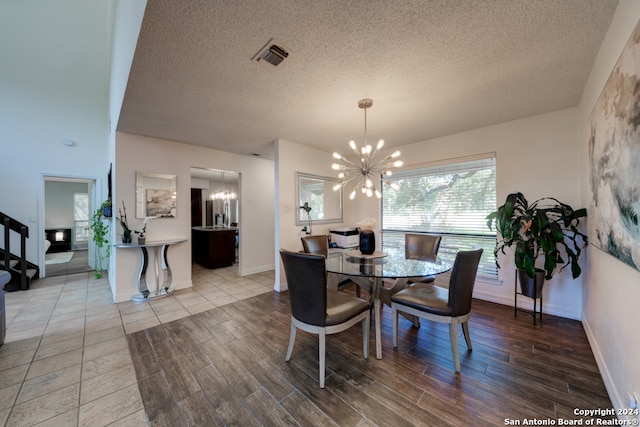 dining space with hardwood / wood-style flooring, a notable chandelier, and a textured ceiling