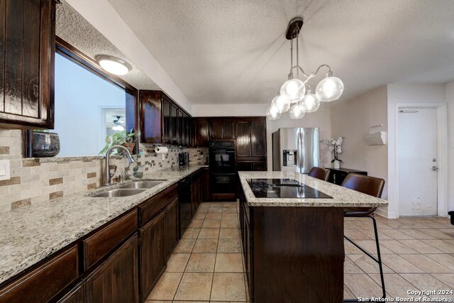 kitchen featuring backsplash, sink, black appliances, light tile patterned floors, and a kitchen island