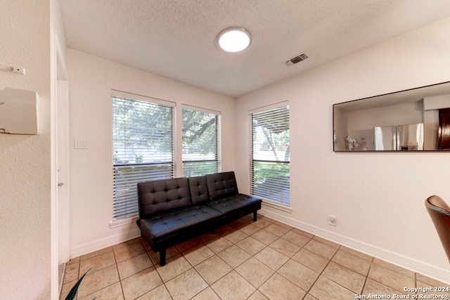 sitting room featuring a textured ceiling and light tile patterned floors