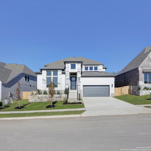 prairie-style house featuring a front lawn and a garage