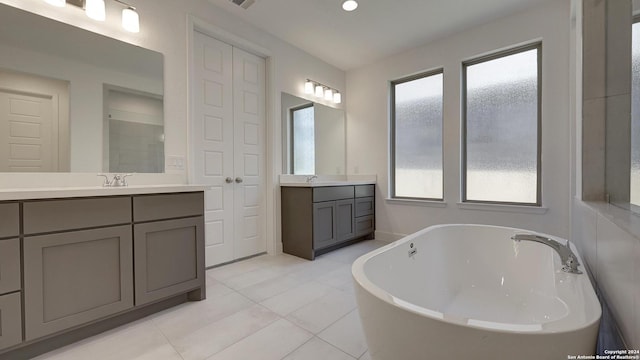 bathroom with tile patterned flooring, vanity, plenty of natural light, and a bathing tub