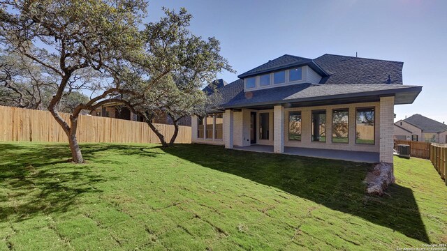 rear view of house with central air condition unit, a yard, and a patio