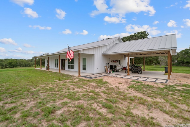 rear view of property with metal roof and a lawn