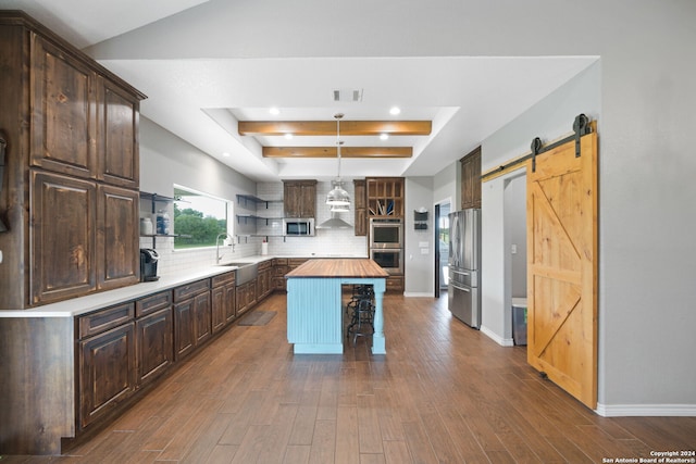 kitchen with a barn door, butcher block countertops, a center island, open shelves, and decorative light fixtures