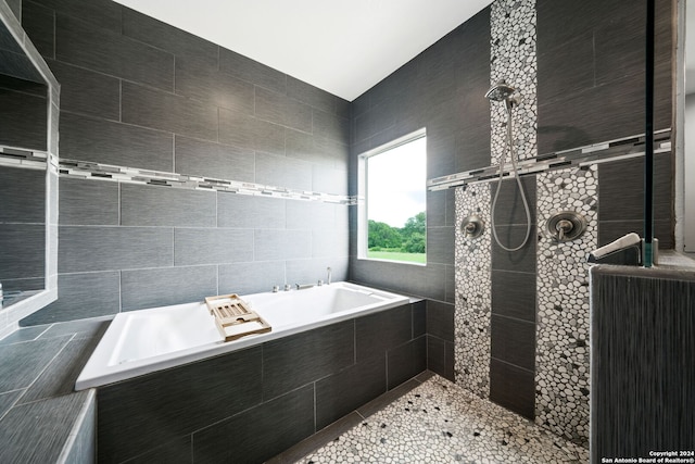 bathroom featuring a tile shower and a bath