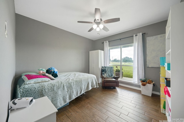 bedroom with ceiling fan, dark wood finished floors, and baseboards