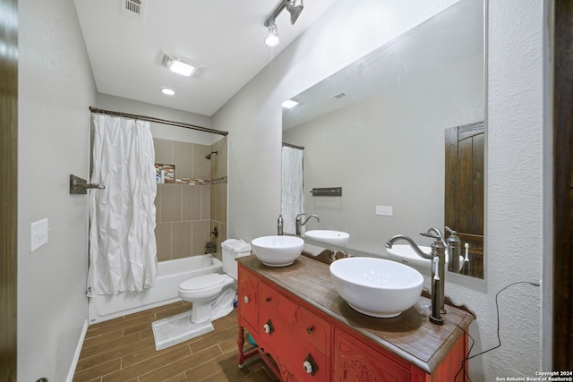 full bath with wood tiled floor, shower / bath combo with shower curtain, and a sink