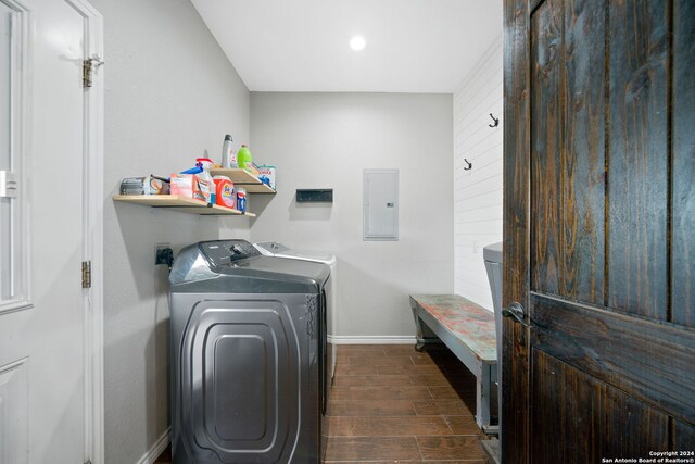 laundry room with laundry area, baseboards, electric panel, wood tiled floor, and washing machine and clothes dryer