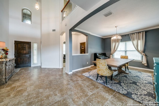 dining room with arched walkways, crown molding, a notable chandelier, visible vents, and baseboards