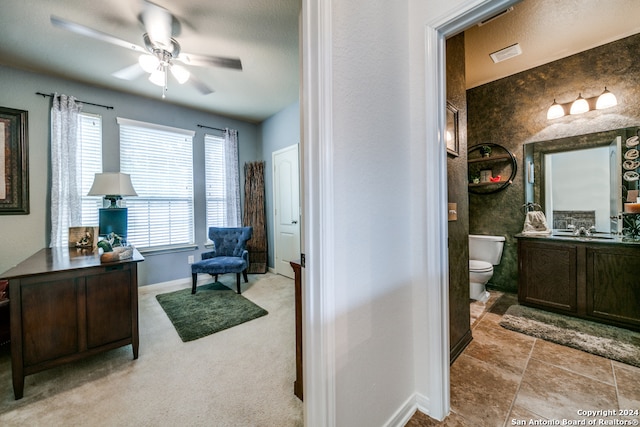 interior space featuring tile patterned floors, ceiling fan, vanity, and toilet