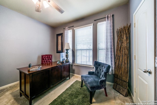 office space with light carpet, baseboards, and a ceiling fan