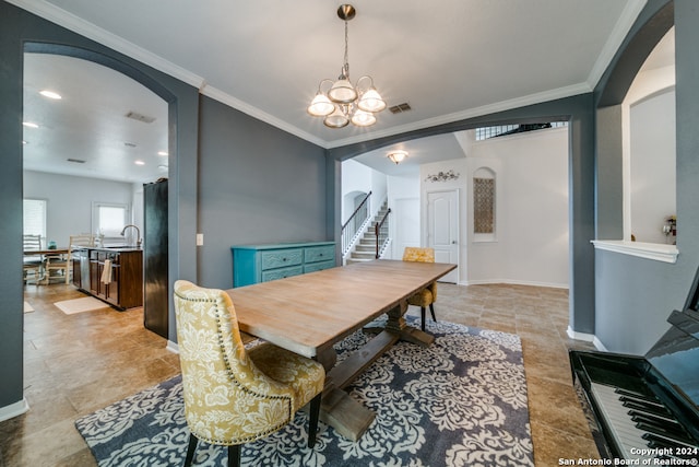 tiled dining space with sink, crown molding, and an inviting chandelier