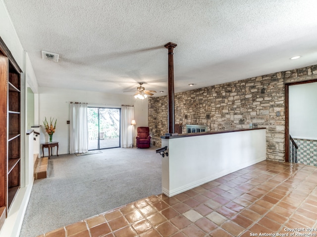 interior space with carpet flooring, ceiling fan, and a textured ceiling