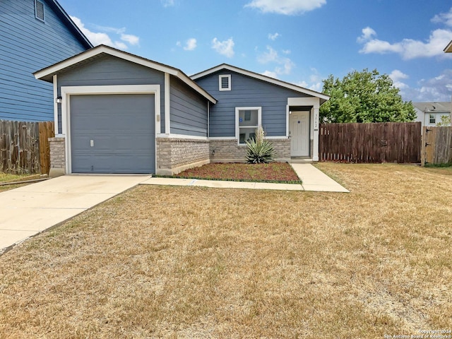 view of front of house with an attached garage, driveway, fence, and a front yard