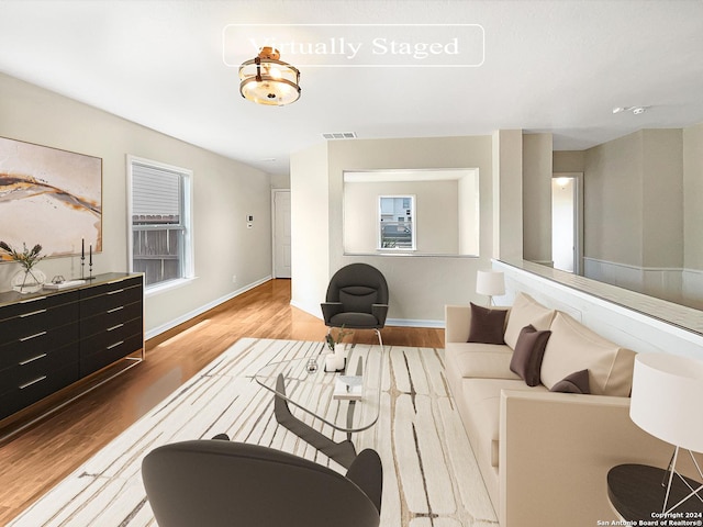 living room with visible vents, baseboards, and wood finished floors